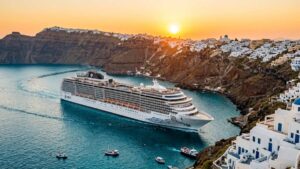 7 Best Greek Islands Cruises: #1 Ultimate Mediterranean Guide 1 Luxury cruise ship anchored near the volcanic caldera of Santorini at sunset