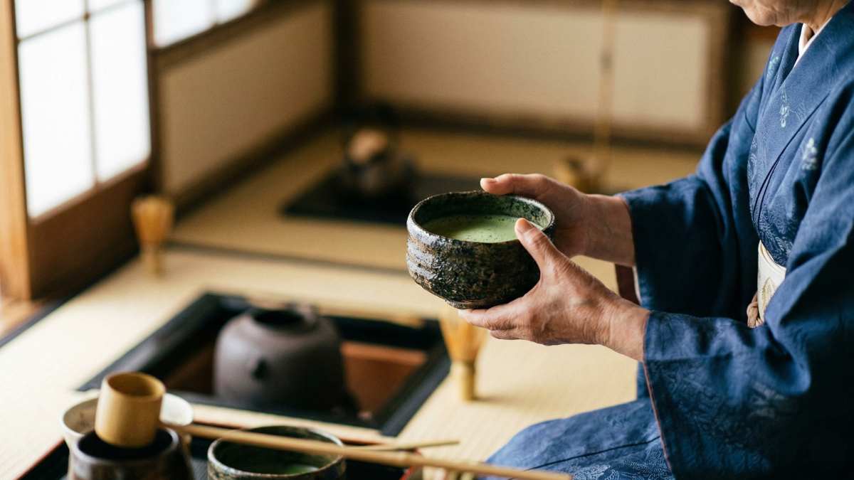 Close-up of a private tea ceremony performing with rustic ceramic bowl during an Exclusive Japan Travel experience.