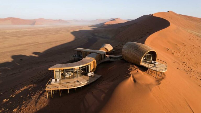 A futuristic luxury desert lodge nestled in the red dunes of Sossusvlei, a top Luxury Namibia Safari destination.