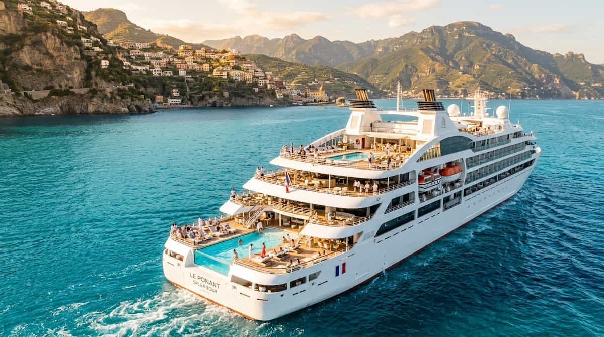 Ultra-luxury cruise ship sailing off the coast of Positano with an infinity pool on deck.