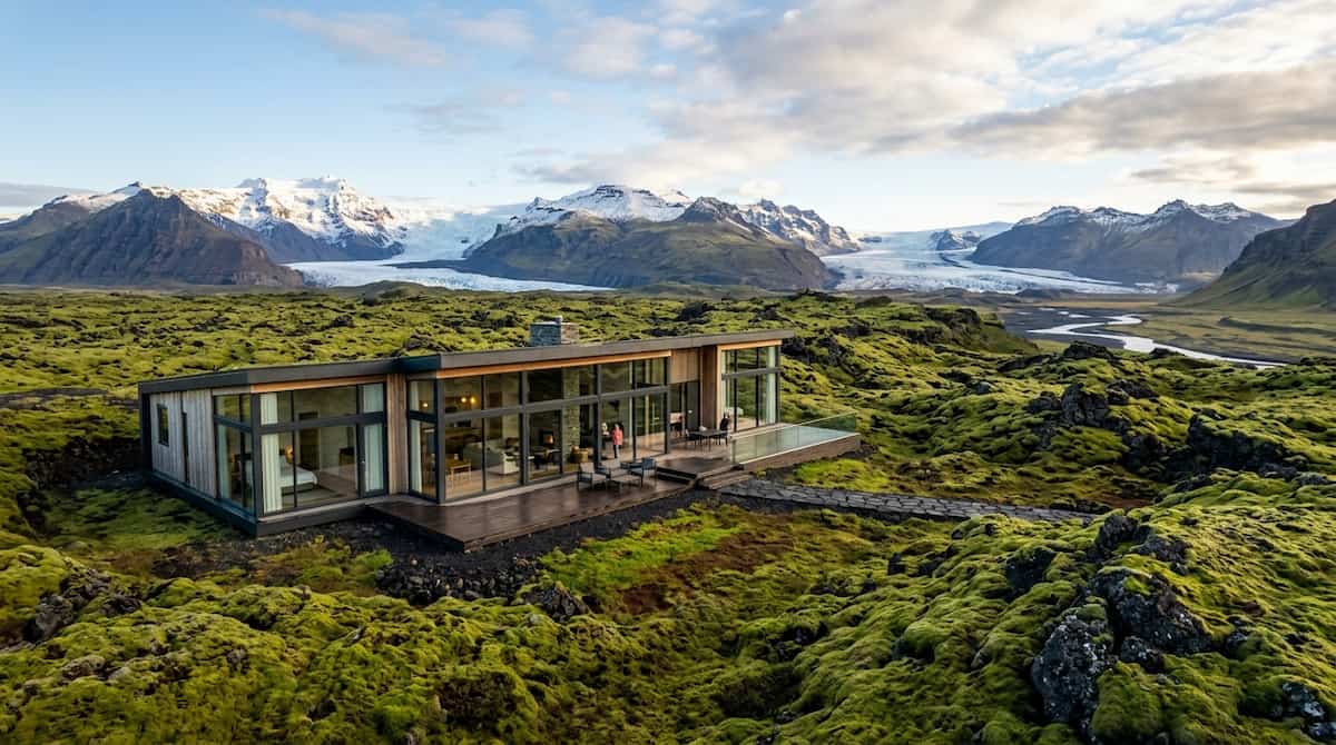 A comprehensive Iceland luxury guide showcasing an exclusive glass cabin resort surrounded by volcanic moss landscapes